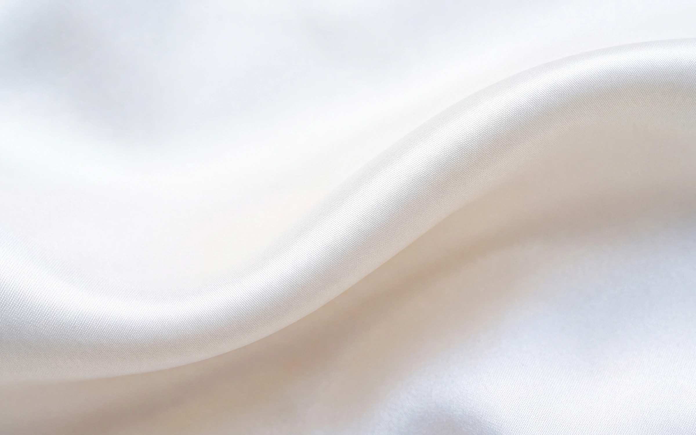 White silk satin curving across the frame in one broad wave with a soft satin sheen.