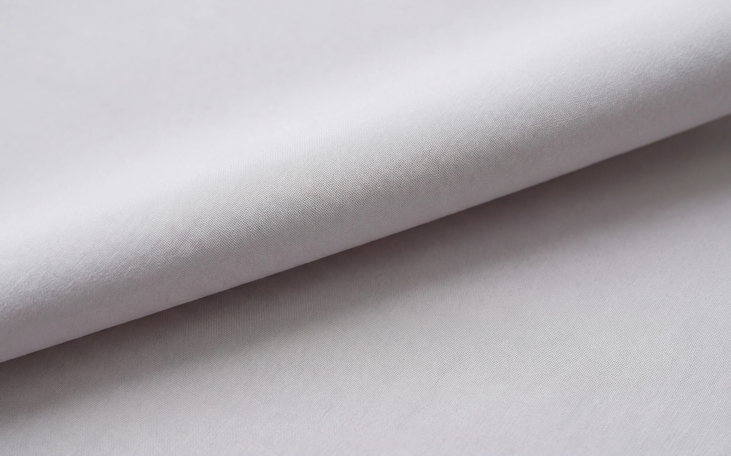 Light grey white fabric resting in one shallow fold, completely matte.